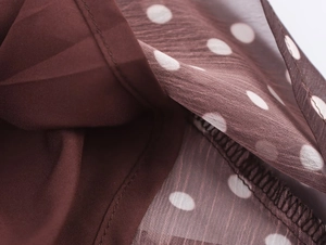 Détail du tissu marron à pois avec coutures de haute qualité et texture fine