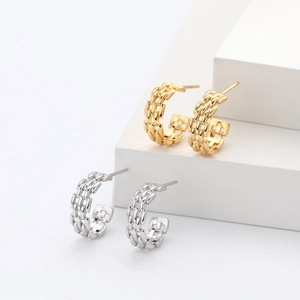 Macro shot of C-shaped woven chain stud earrings in polished gold and silver finishes