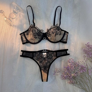 Détail de lingerie en maille brodée noire avec pendentif en strass en forme de cœur