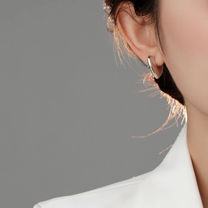 Close-up of heart-shaped silver earrings showing metallic luster and minimalist design