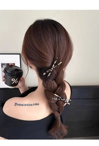 Detailed view of two leopard print hair clips worn on a braided hairstyle for women
