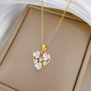 Luxurious gold heart pendant necklace featuring shell flowers and cubic zirconia in a jewelry box