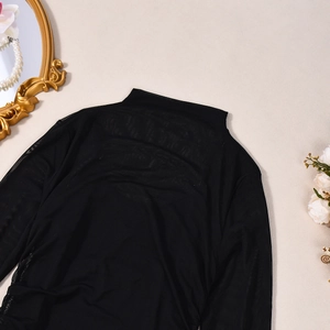 Détail du haut à manches longues en maille noire transparente avec col montant élégant