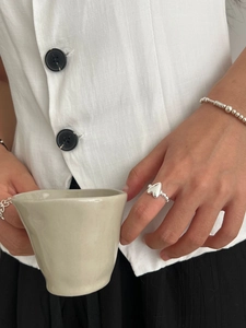 Detail of 925 sterling silver heart ring with beaded band worn by a model