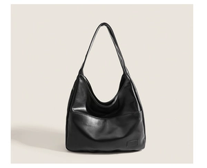 Detailed view of the smooth black leather texture and hobo style of the shoulder bag
