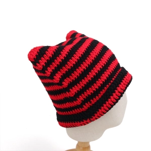 Detailed knit texture of red and black striped cat ear beanie on a white model head