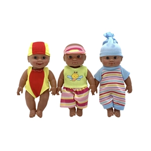 Three African-style vinyl baby dolls in colorful outfits standing on white background