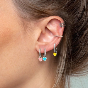 Vue macro des boucles d'oreilles cœur en émail et des bagues d'oreille en zircone cubique