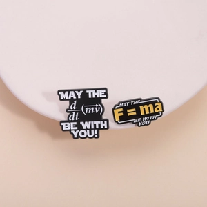 Creative physics enamel pins featuring F=ma and d/dt(mv) formulas on sleek white props