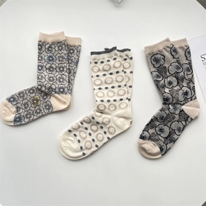 Detailed macro view of three vintage cotton socks with floral and circular patterns