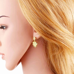Detail view of gold heart drop earrings featuring double heart pendants worn by a model