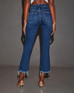 Dettaglio posteriore dei jeans a zampa blu scuro slim fit con orlo sfrangiato e nappe