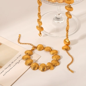Detailed shot of 18K gold shell link necklace and bracelet set with metallic luster