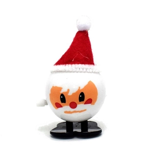 Detail view of a white spherical wind-up Christmas toy with red hat and black feet