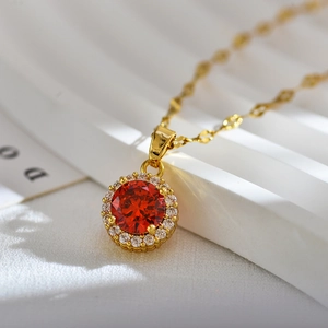 Elegant gold necklace with a round red crystal pendant and halo diamond setting