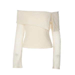 Detail showing creamy white off-shoulder knit top with unique textured dotted fabric pattern
