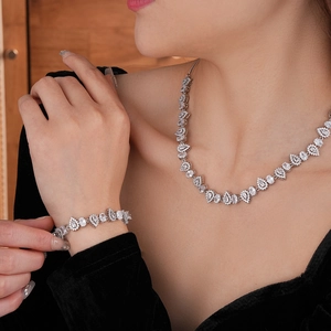 Close-up of elegant silver necklace and bracelet set with teardrop zircon stones on model