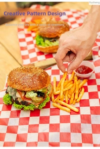 Close-up of red checkered greaseproof paper for wrapping burgers and fries on wood table