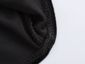 Detailed close-up of premium black velvet texture and professional edge stitching on dress
