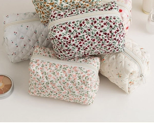 Detailed view of stacked quilted floral cotton makeup bags in various vibrant patterns