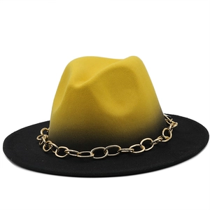 Detail of yellow and black gradient felt hat featuring a chunky gold metal chain decoration