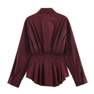 Detail of the pleated waist structure and woven texture on this burgundy long sleeve shirt
