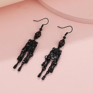 Gothic black skull drop earrings with red crystal eyes on a pink geometric background
