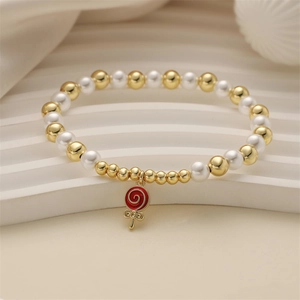 Golden beads and white pearls bracelet featuring a red lollipop spiral heart charm
