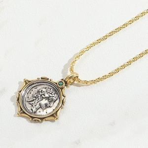 Detail of vintage coin pendant with green gemstone on a golden twisted chain
