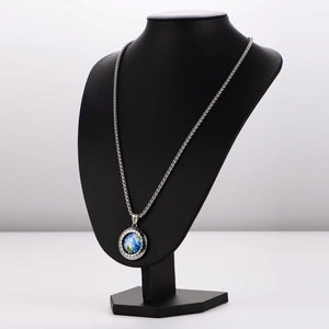 Minimalist silver hip hop globe necklace with Greek pattern on a black mannequin