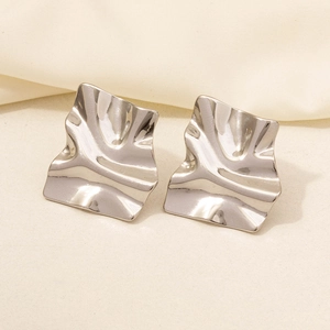 Close-up of silver-plated stainless steel earrings with wavy texture and mirror finish