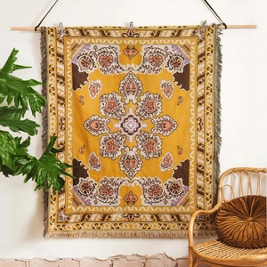 Close-up of bohemian woven blanket with mustard yellow patterns and tassel details