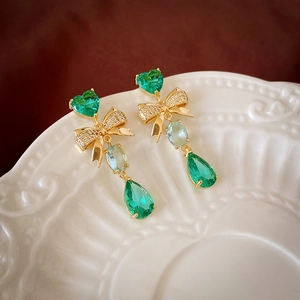 Vue détaillée de boucles d'oreilles vintage dorées avec cœur vert et zircon poire