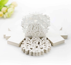 Detail of laser-cut butterfly candy box with white ribbon for wedding favors