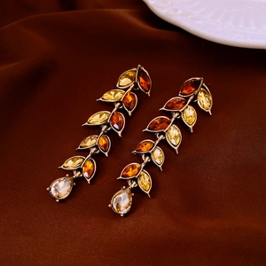 Detail of vintage leaf pendant featuring amber and yellow crystals on brown silk