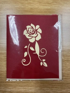 Detail view of 3D pop-up rose greeting card with hollow patterns in plastic packaging
