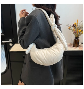 Sac croissant matelassé blanc avec bandoulière nouée montré dans une scène d'utilisation