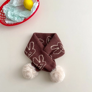 Detailed flat lay of a dark brown knit scarf for kids with rabbit motifs and faux fur pom-poms
