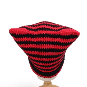 Close-up of red and black striped crochet texture on a cat ear knit beanie hat