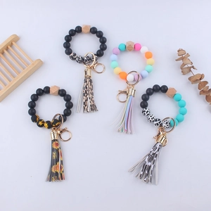 Detail view of silicone bead wristlet keychains with leather tassels and leopard patterns