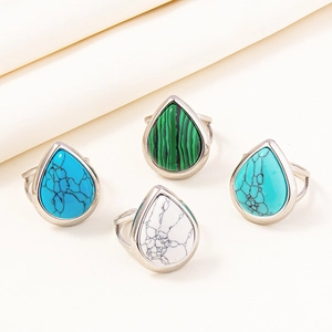 Macro shot of silver adjustable rings featuring teardrop stones in green, blue, and white