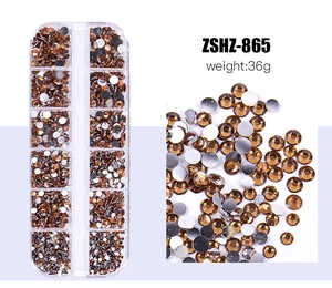 Detailed view of brown resin flatback rhinestones in a 12-grid organizer box for DIY nail art