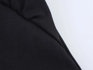 Vista macro dettagliata della trama del tessuto a maglia nera e delle cuciture dei bordi