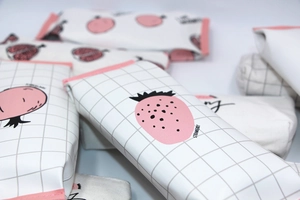Close-up of strawberry print PU pencil case featuring a pink zipper and textured finish