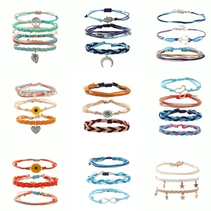 Detail of colorful handmade woven beaded bracelets with shell and pearl charms