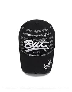 Détail d'une casquette en coton noir avec broderie blanche et bordure à effet usé