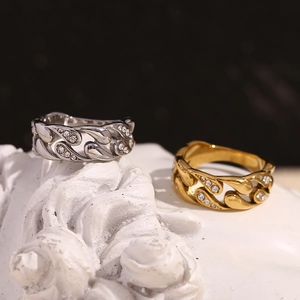 Detail of 18K gold and silver rings with hollow chain design and sparkling crystals