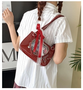 Close-up of red patent leather ita bag with heart window, lace trim and bow detail