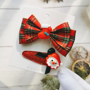 Detail of red plaid bow hair clip and Santa Claus charm for kids Christmas gift set