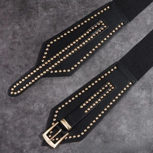 Close-up of black elastic corset belt with golden studs and a rectangular metal buckle